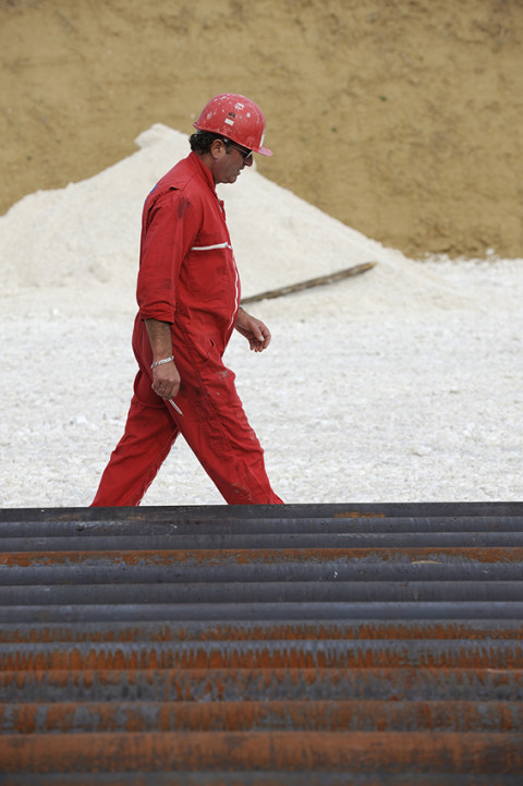 photo fred bourcier ouvrier et tubes acier forages sur site de forage pétrolier